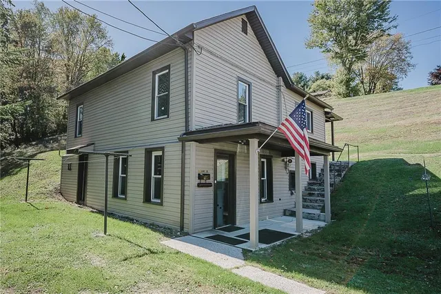 a view of a house with a small yard and wooden fence