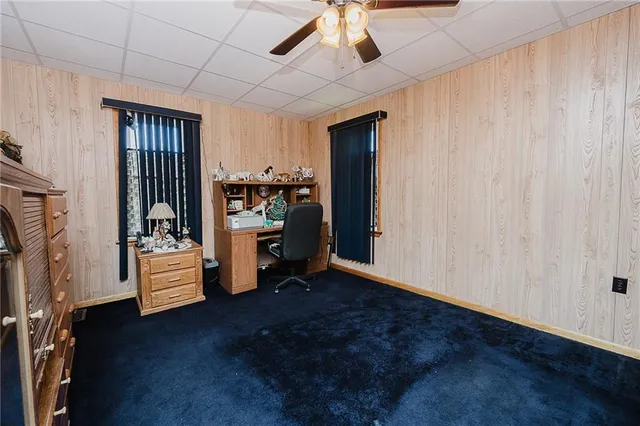 a view of an empty room with kitchen and a window