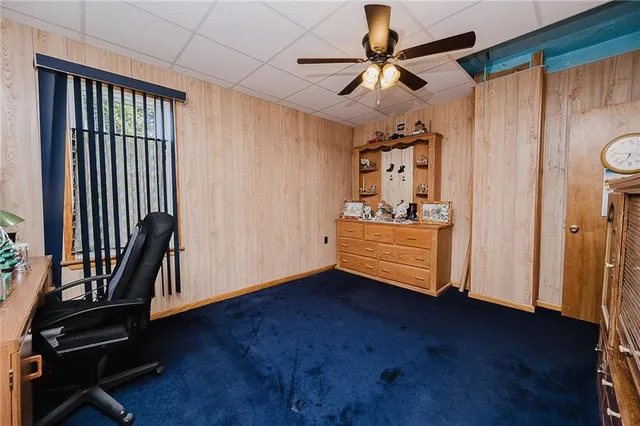 a room with wooden floor and ceiling fan