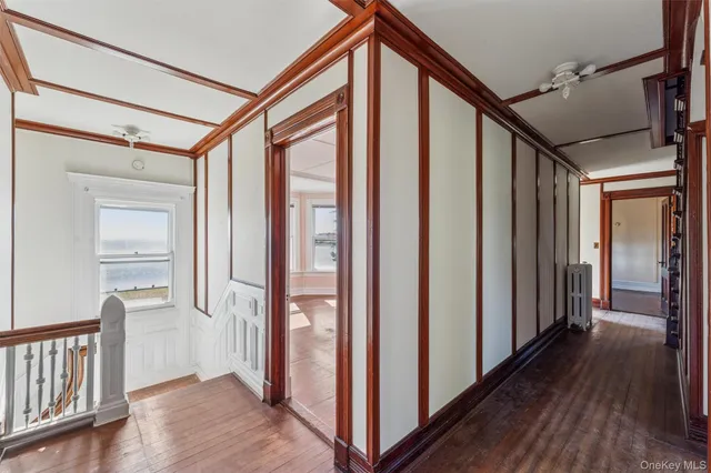 a view of a hallway with wooden floor and staircase