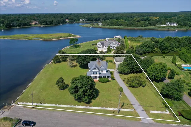 an aerial view of a residential houses with outdoor space and lake view