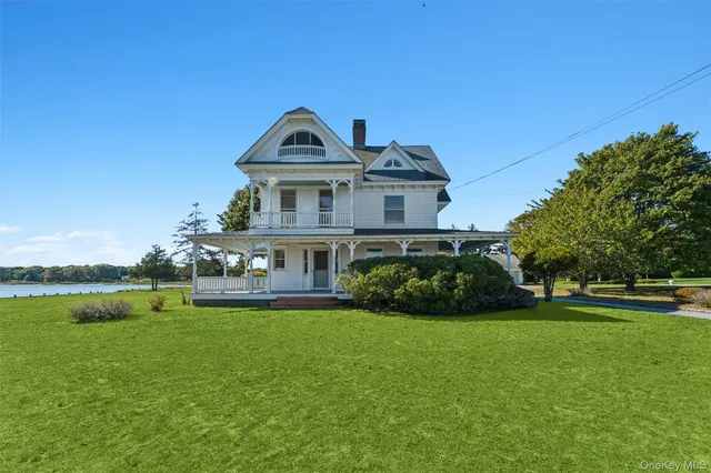 a view of a house with a big yard potted plants and large tree