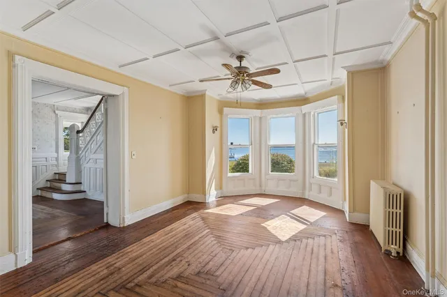 a view of a livingroom with wooden floor and a ceiling fan