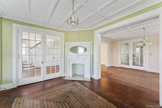 a view of empty room with wooden floor and fireplace