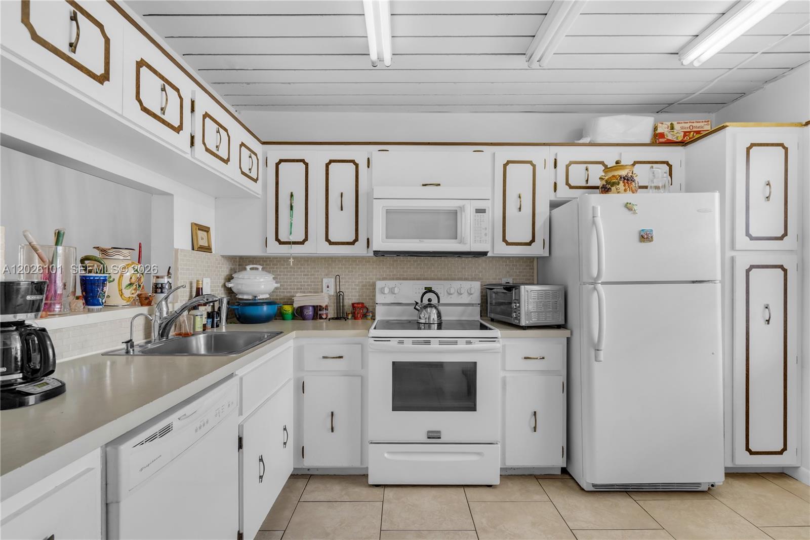 3551 Inverrary Drive, Unit 208 Lauderhill, FL 33319 - Photo 3 of 34 a kitchen with white cabinets and white appliances