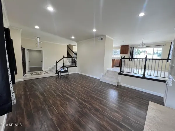 a view of a living room with wooden floor and windows