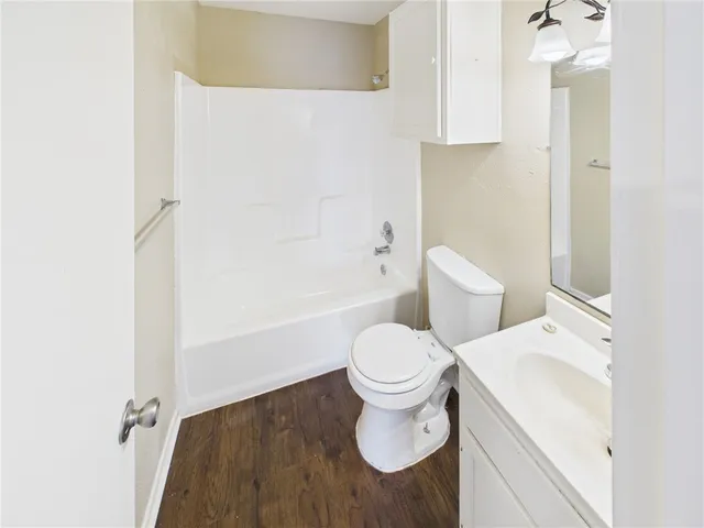 a white toilet sitting next to a bathroom sink and a shower