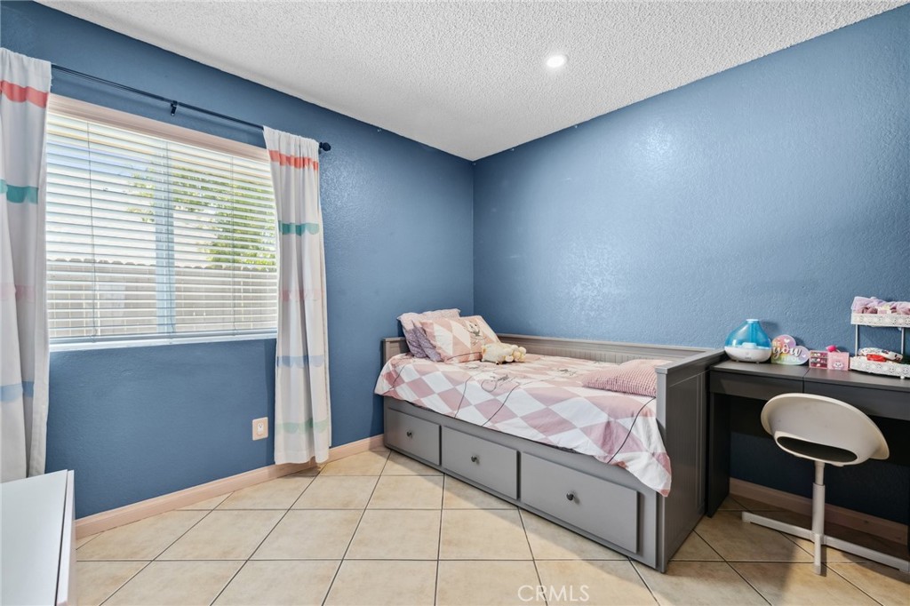 129 Avocado Avenue Perris, CA 92571 - Photo 17 of 30 a bedroom with a bed and a chair