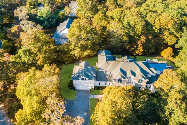a view of a house with a big yard and large trees