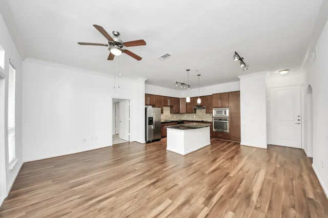 a view of a kitchen with wooden floor and a ceiling fan