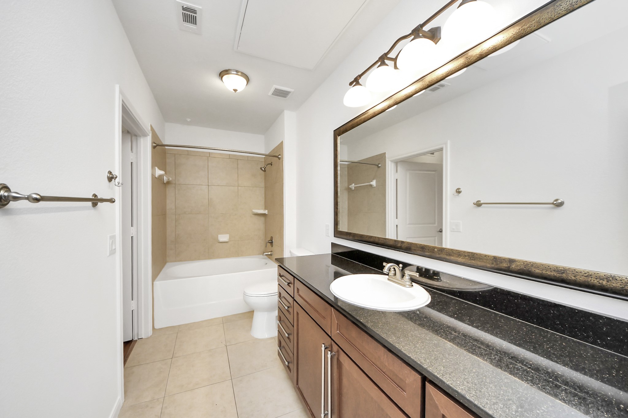 6363 San Felipe Street, Unit 465 Houston, TX 77057 - Photo 28 of 49 a bathroom with a granite countertop sink a mirror a bathtub and shower