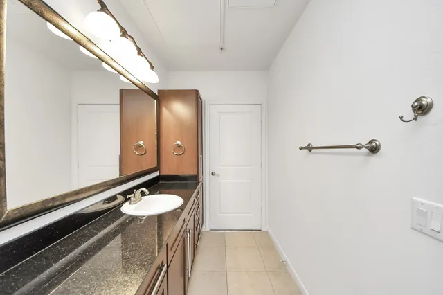 a bathroom with a sink a light fixture and a mirror