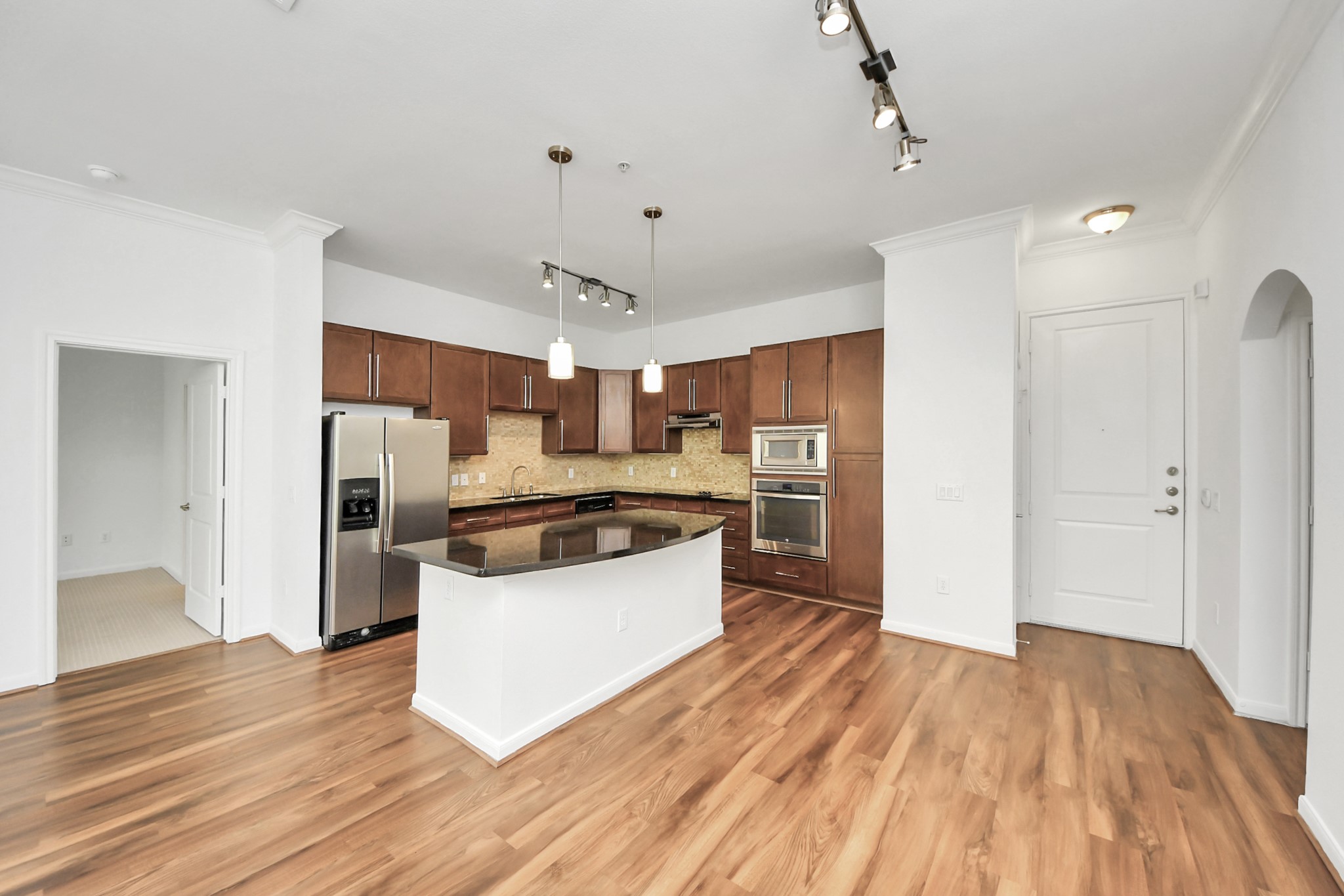 6363 San Felipe Street, Unit 465 Houston, TX 77057 - Photo 5 of 49 a large kitchen with a wooden floor and stainless steel appliances