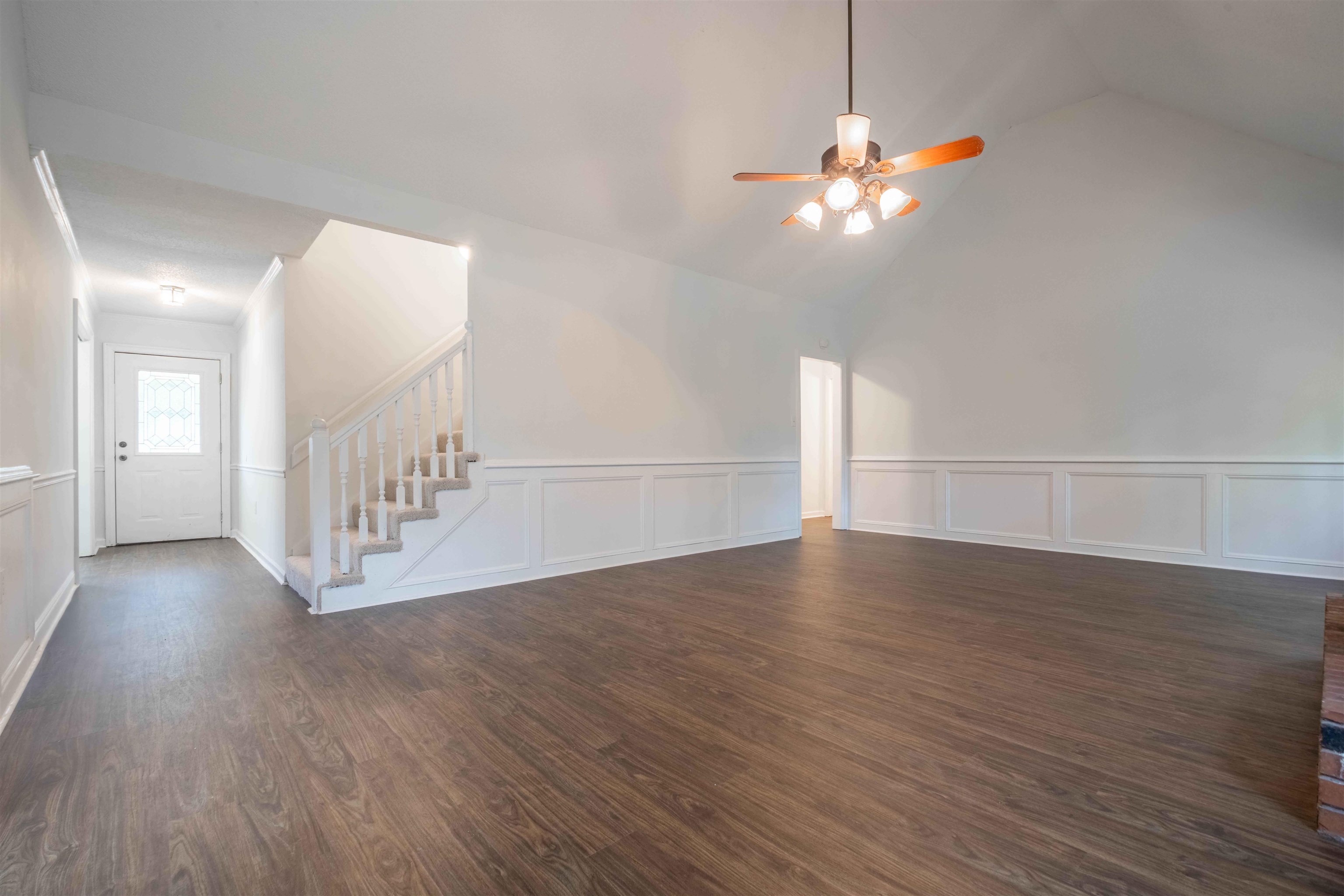 7800 Buck Ridge Cove Memphis, TN 38016 - Photo 7 of 36 Spacious interior showcasing wood-finish flooring, wainscoting, and a vaulted ceiling