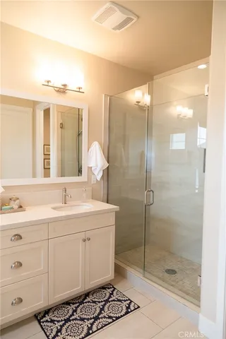 a bathroom with a double vanity sink mirror and shower