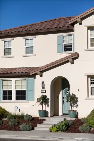 a front view of a house with plants