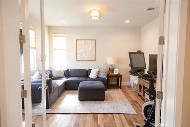 a living room with furniture a flat screen tv and a window