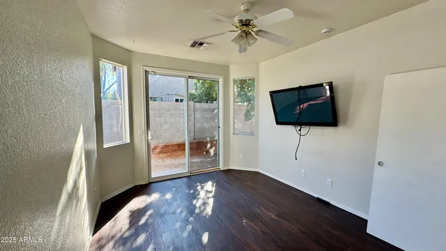 a view of a livingroom with wooden floor and a flat screen tv