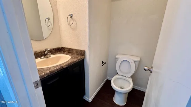 a bathroom with a granite countertop toilet sink and mirror