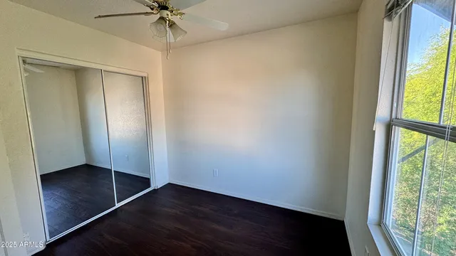 an empty room with window and a ceiling fan