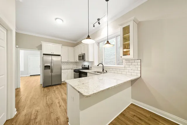 a kitchen with a sink a counter top space stainless steel appliances and cabinets