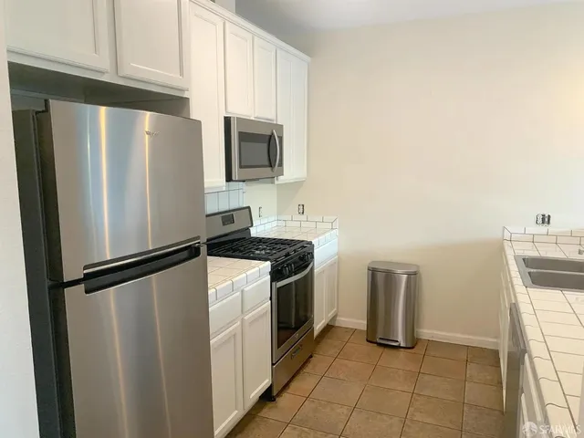 a kitchen with stainless steel appliances a refrigerator sink and microwave