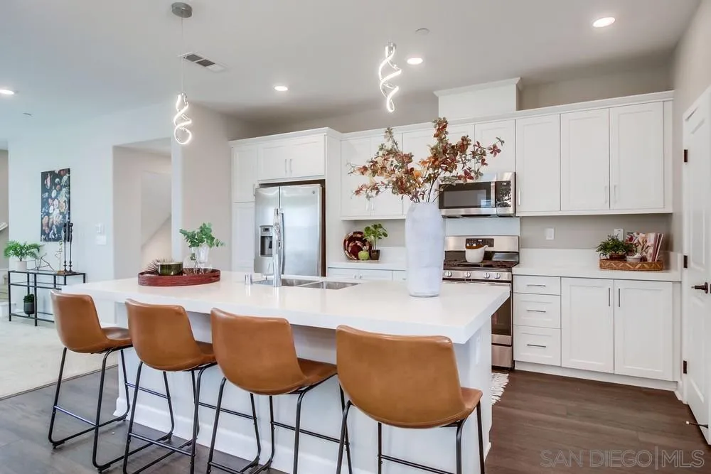 1956 Infinity Lane Chula Vista, CA 91915 - Photo 6 of 58 a kitchen with granite countertop a table chairs stove and cabinets