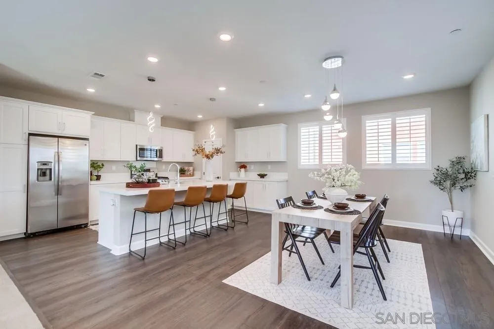 1956 Infinity Lane Chula Vista, CA 91915 - Photo 7 of 58 a view of a dining room with furniture wooden floor and a kitchen