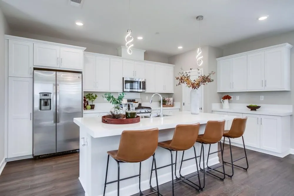 1956 Infinity Lane Chula Vista, CA 91915 - Photo 8 of 58 a kitchen with stainless steel appliances kitchen island granite countertop a dining table chairs refrigerator and sink