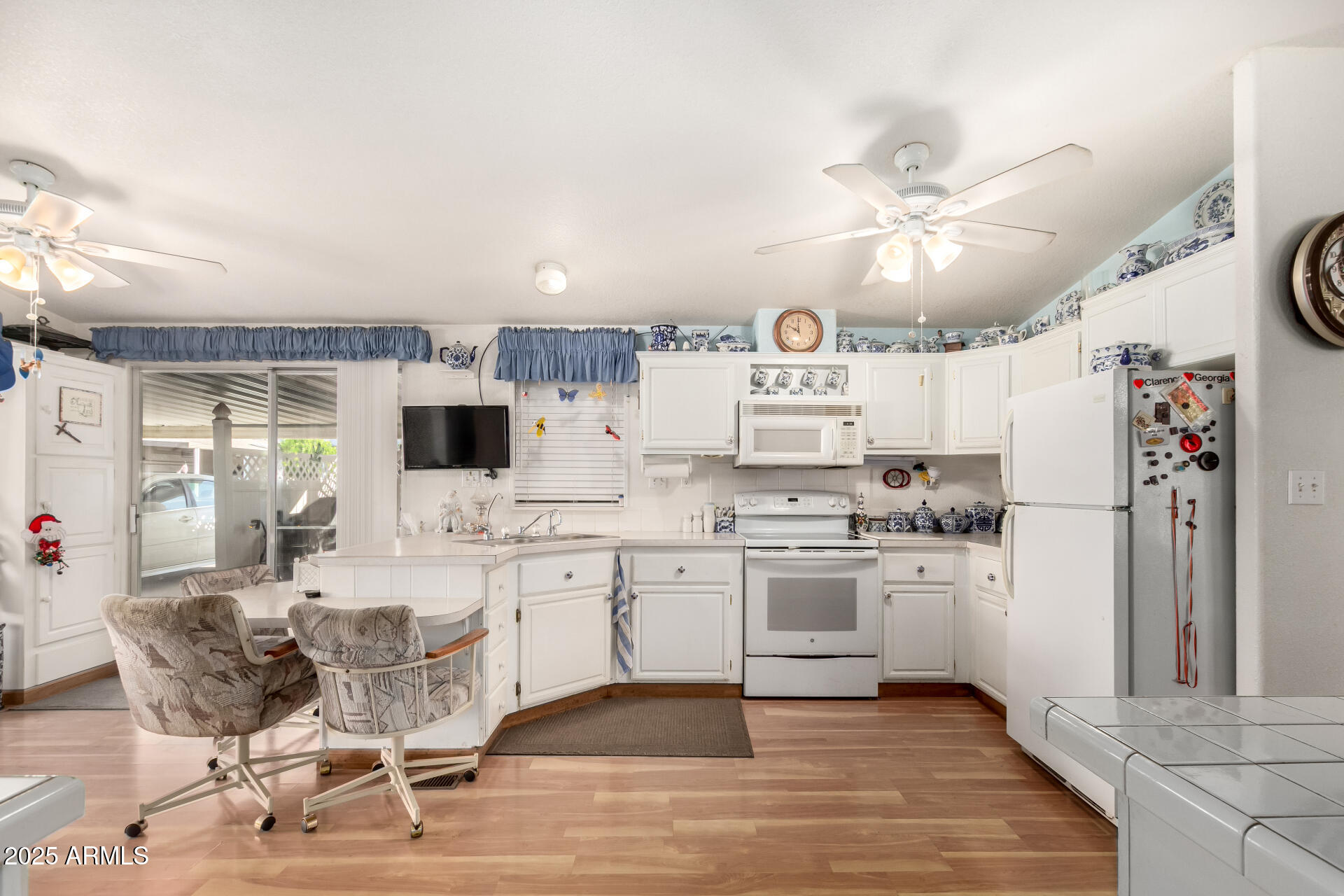 2400 East Baseline Avenue, Unit 148 Apache Junction, AZ 85119 - Photo 17 of 42 a kitchen with stainless steel appliances kitchen island granite countertop a refrigerator a stove a microwave oven a sink with island and chairs