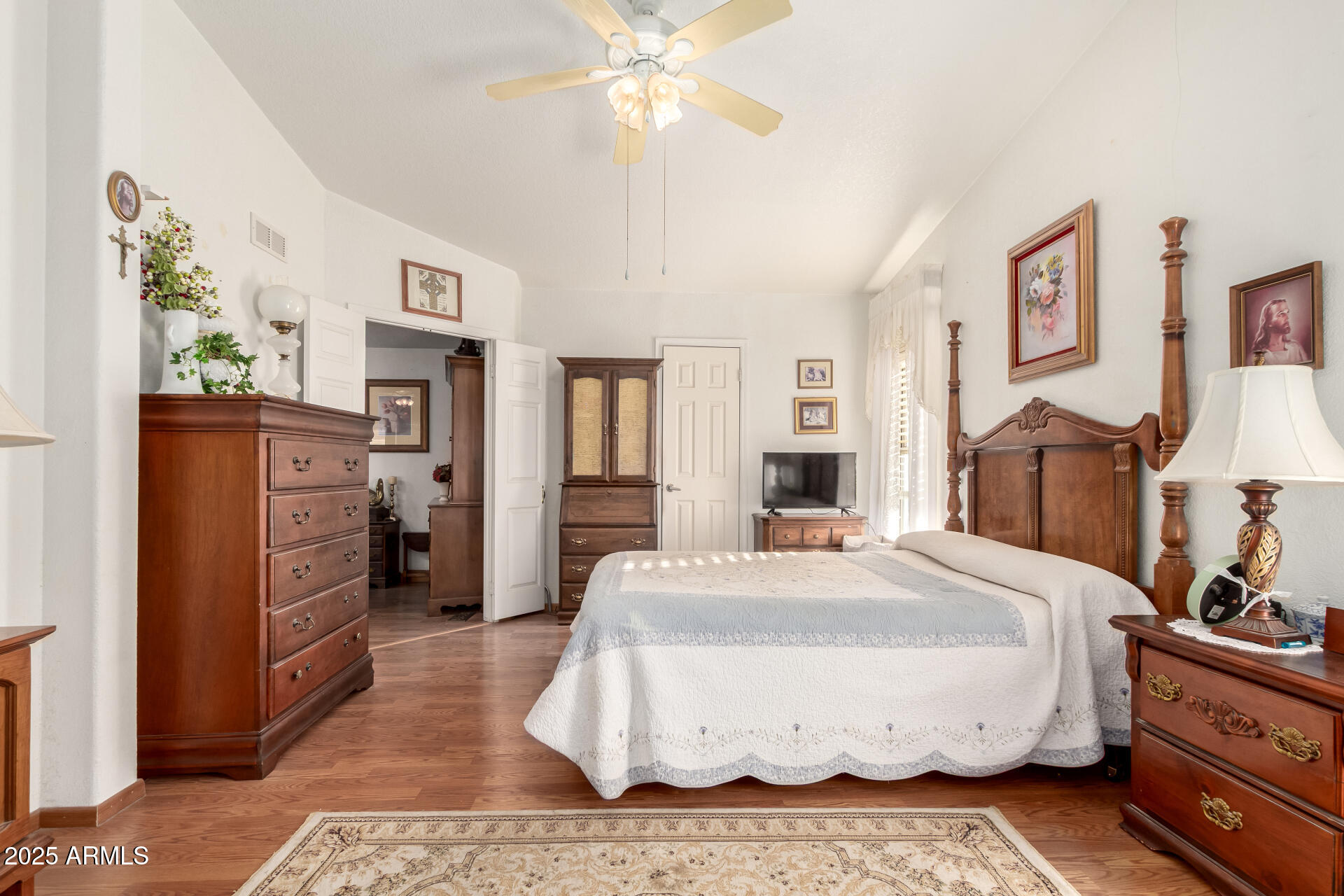 2400 East Baseline Avenue, Unit 148 Apache Junction, AZ 85119 - Photo 21 of 42 a spacious bedroom with a bed and a chandelier
