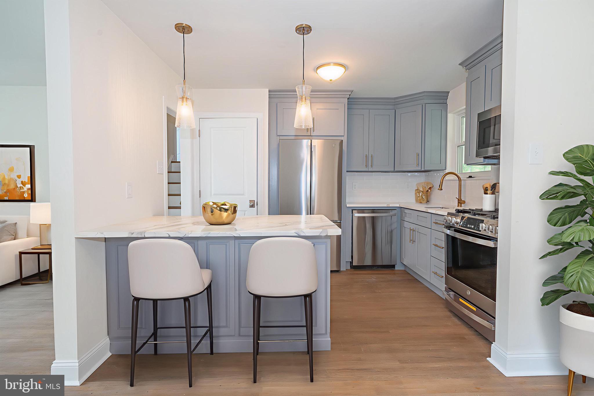 503 Poplar Road Flourtown, PA 19031 - Photo 16 of 63 a kitchen with stainless steel appliances wooden floor dining table and chairs