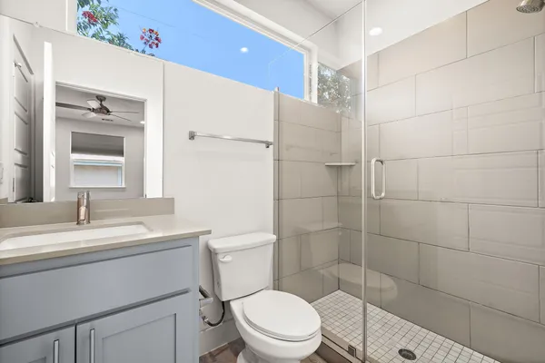 a bathroom with a sink a toilet and shower