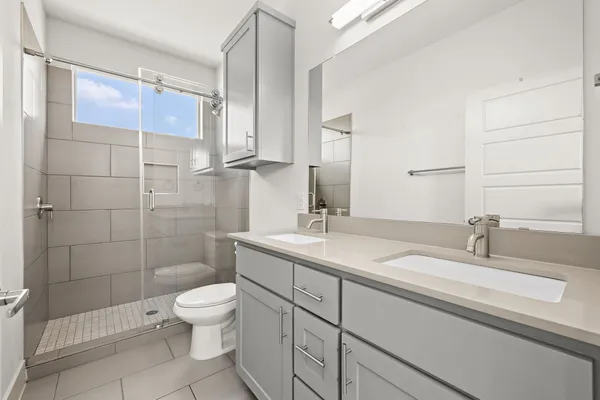 a bathroom with a sink a toilet and shower