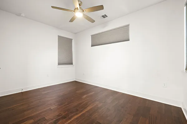 a view of an empty room with wooden floor