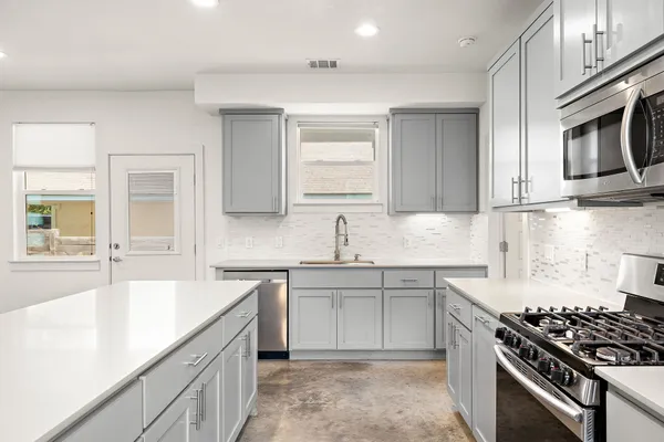 a kitchen with stainless steel appliances a sink stove and cabinets