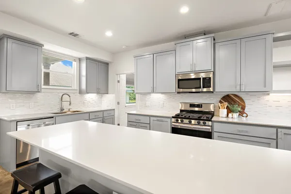a kitchen with a stove a sink and a refrigerator