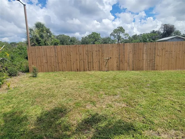 a view of backyard with wooden fence