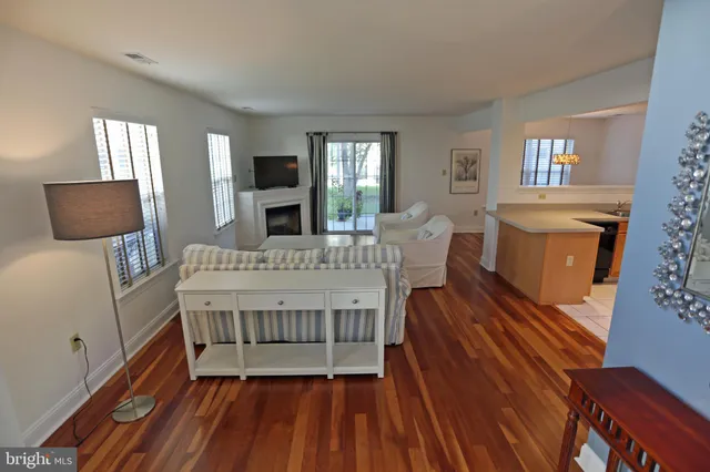 a view of a white house with large windows next to a road