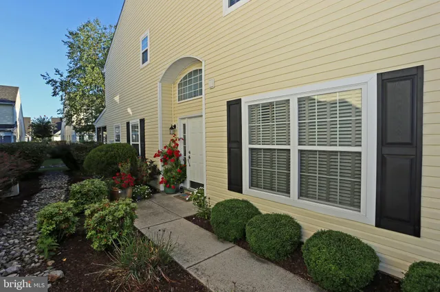 a front view of a house with plants