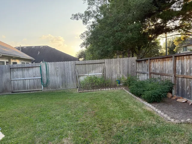 a view of a backyard with potted plants and wooden fence