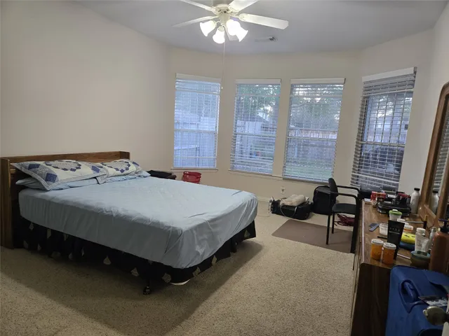 a bedroom with a bed a large window and chandelier