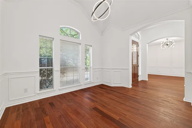 an empty room with wooden floor and ceiling fan