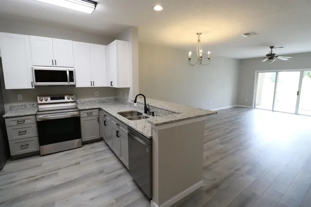 a kitchen with a sink stove a microwave and cabinets