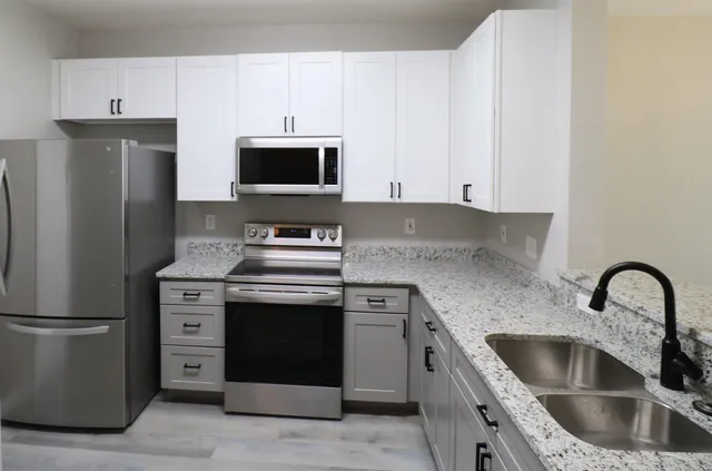a kitchen with white cabinets and stainless steel appliances