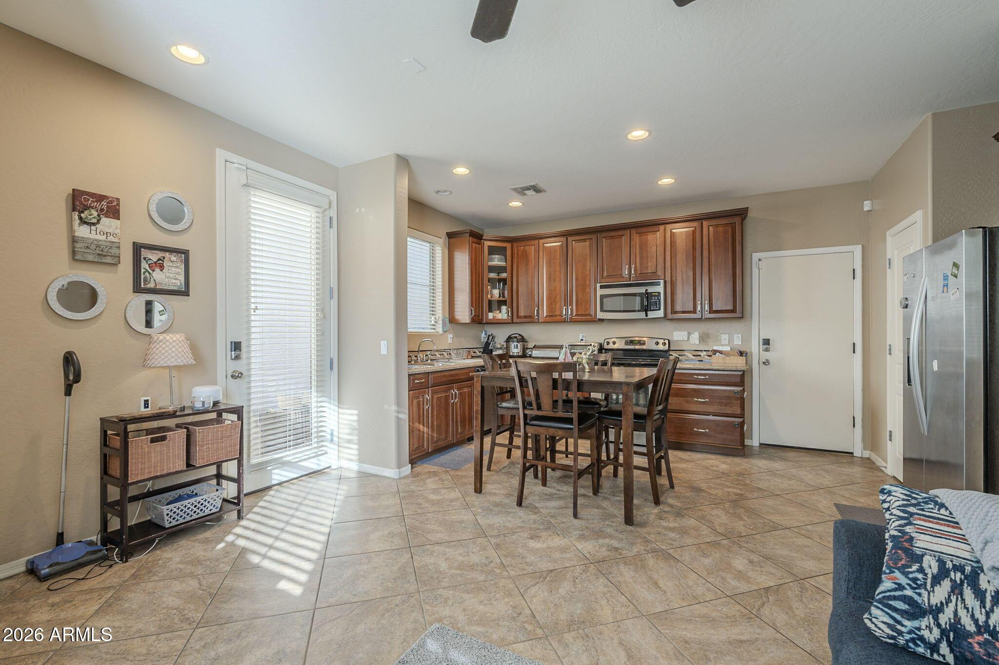 451 South Hawes Road, Unit 45 Mesa, AZ 85208 - Photo 7 of 36 a kitchen with stainless steel appliances granite countertop a stove top oven a sink a dining table and chairs