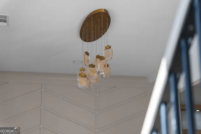 a view of a big room with chandelier fan and windows