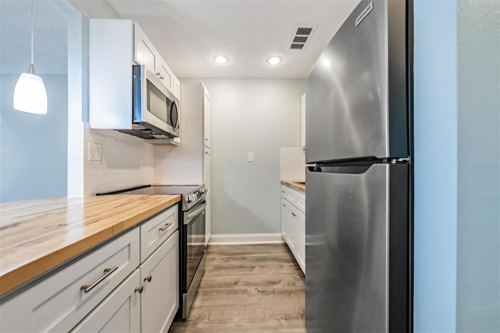233 South McMullen Booth Road, Unit 43 Clearwater, FL 33759 - Photo 5 of 23 a view of a kitchen with stainless steel appliances granite countertop a refrigerator and a sink