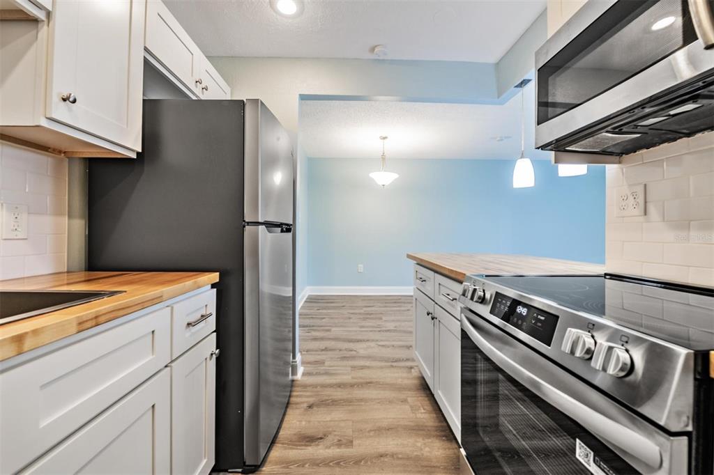 233 South McMullen Booth Road, Unit 43 Clearwater, FL 33759 - Photo 7 of 23 a kitchen with stainless steel appliances granite countertop a stove and a refrigerator