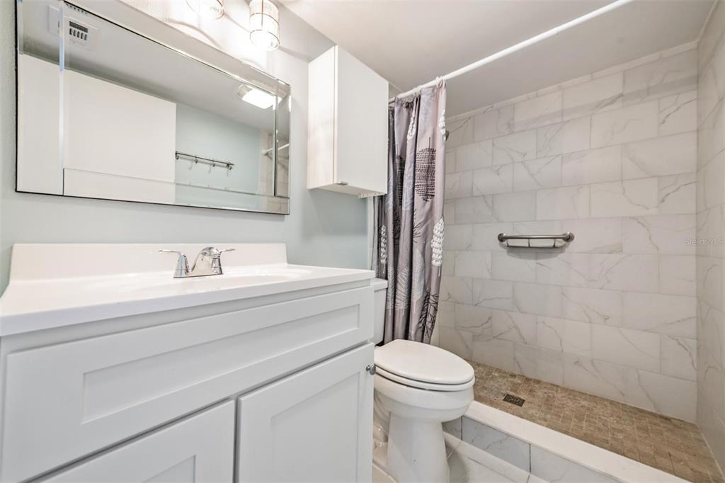 233 South McMullen Booth Road, Unit 43 Clearwater, FL 33759 - Photo 10 of 23 a bathroom with a sink a toilet and shower